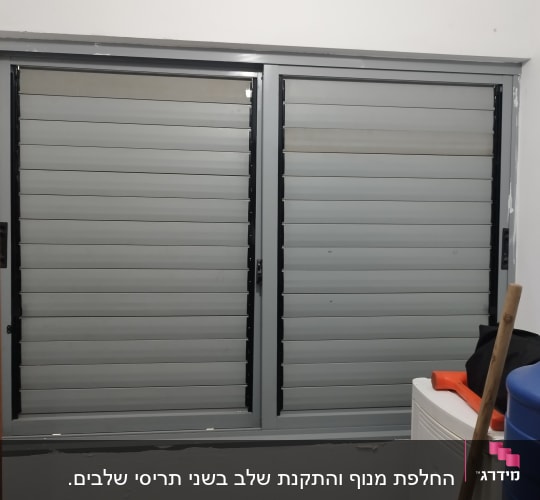 שני תריסים אפורים סגורים עם מסגרת שחורה